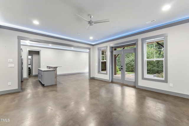 unfurnished living room with a ceiling fan, baseboards, visible vents, and concrete floors
