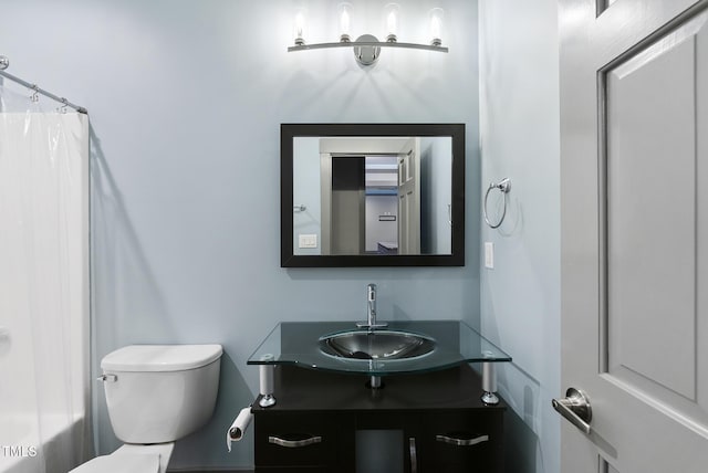 bathroom with vanity, toilet, and curtained shower