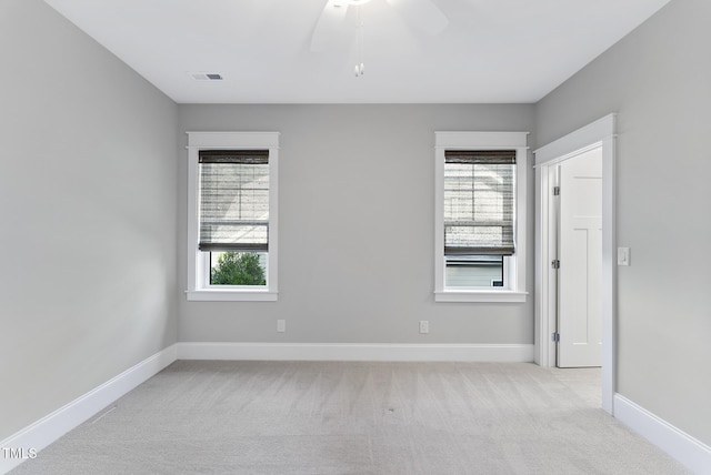 unfurnished room featuring baseboards, light carpet, and a ceiling fan