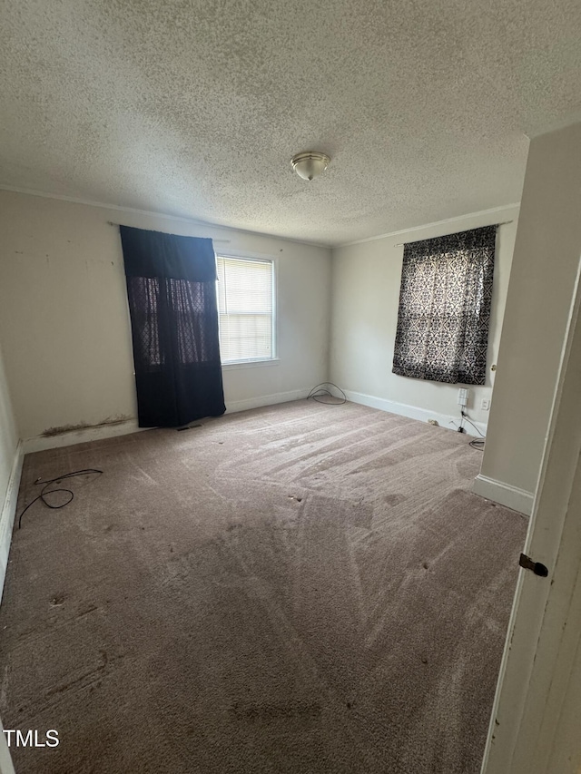 unfurnished room featuring baseboards, carpet flooring, and a textured ceiling