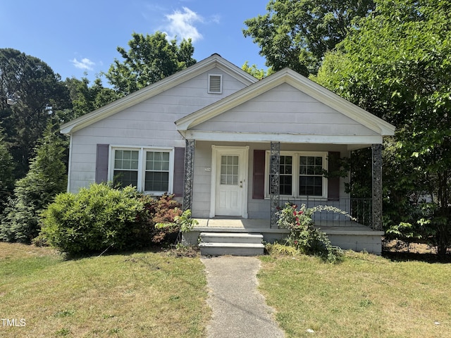 bungalow featuring a porch and a front lawn