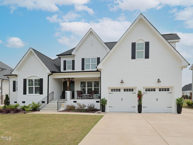 1180 Duke Farm Dr, Wake Forest, NC 27587 - traditional-style house featuring a garage, board and batten siding, driveway, covered porch, and a front lawn
