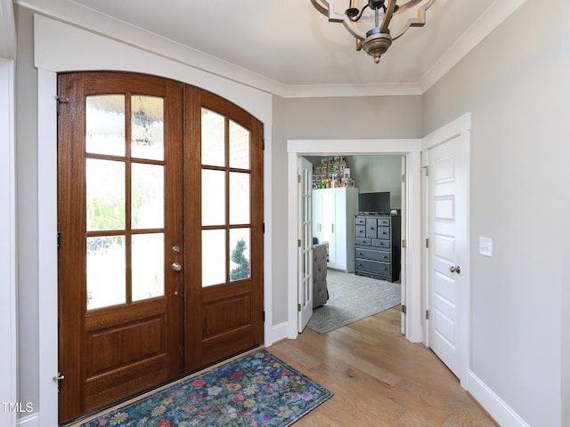 1180 Duke Farm Dr, Wake Forest, NC 27587 - entryway with french doors, light wood-style floors, a chandelier, baseboards, and crown molding
