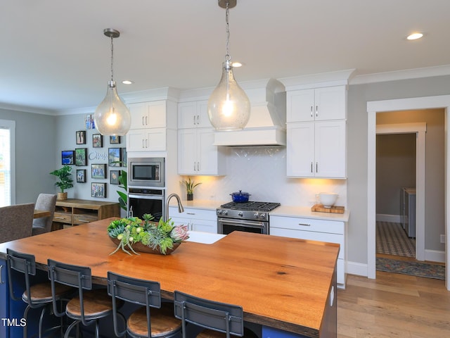 1180 Duke Farm Dr, Wake Forest, NC 27587 - kitchen with custom range hood, stainless steel appliances, white cabinets, crown molding, and backsplash