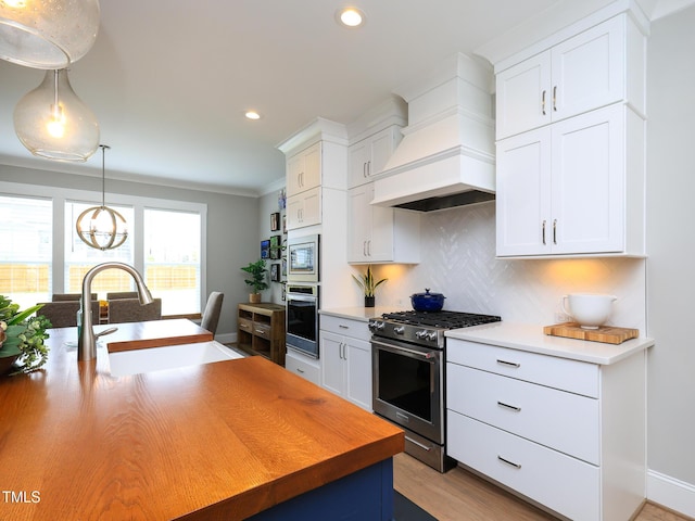 1180 Duke Farm Dr, Wake Forest, NC 27587 - kitchen featuring appliances with stainless steel finishes, a sink, premium range hood, backsplash, and white cabinets