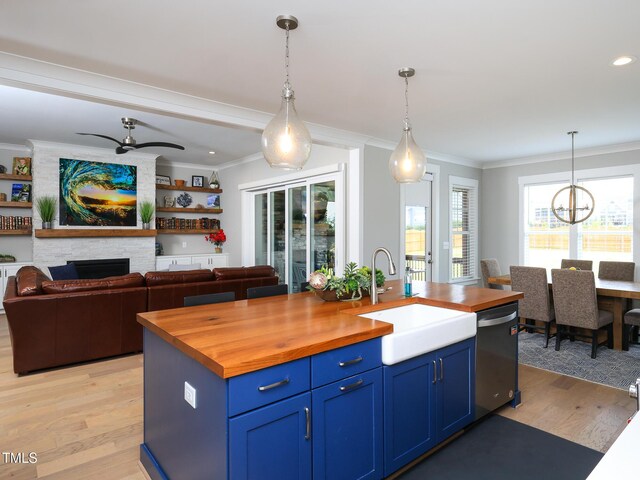 1180 Duke Farm Dr, Wake Forest, NC 27587 - kitchen with wood counters, stainless steel dishwasher, blue cabinets, a sink, and light wood-type flooring