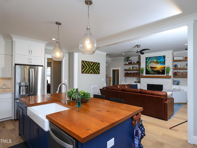 1180 Duke Farm Dr, Wake Forest, NC 27587 - kitchen featuring wood counters, a sink, stainless steel appliances, light wood-type flooring, and crown molding