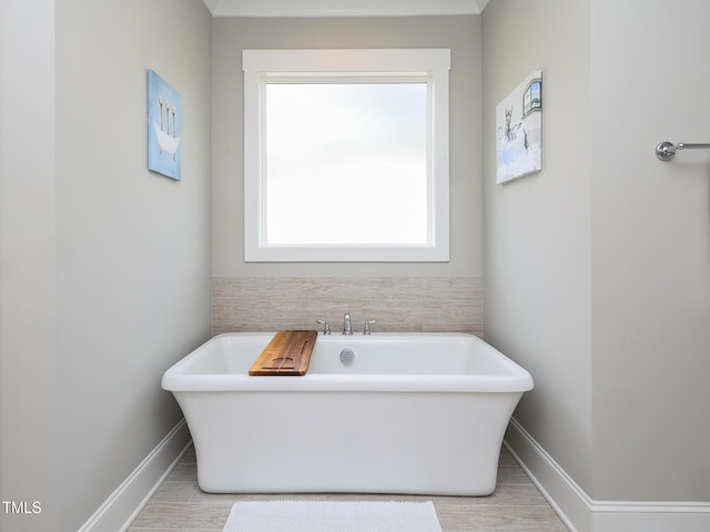 1180 Duke Farm Dr, Wake Forest, NC 27587 - bathroom featuring a soaking tub, baseboards, and wood finished floors