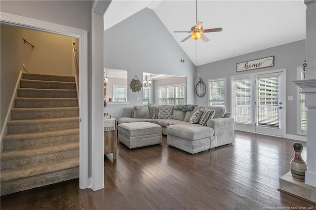 living area featuring stairway, high vaulted ceiling, ceiling fan with notable chandelier, and dark wood finished floors