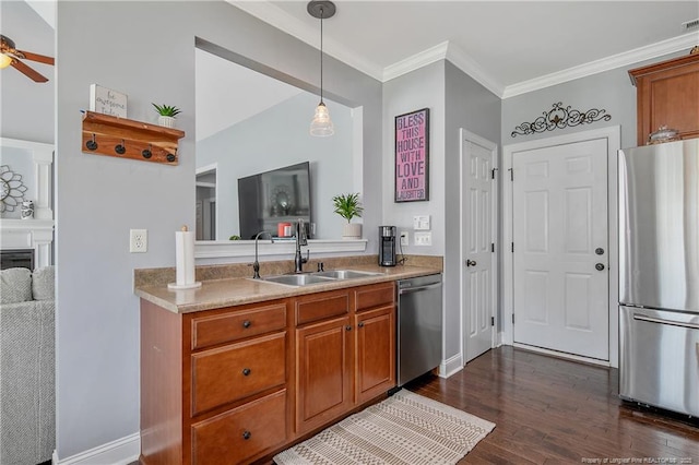 kitchen with a ceiling fan, ornamental molding, dark wood-type flooring, a sink, and appliances with stainless steel finishes