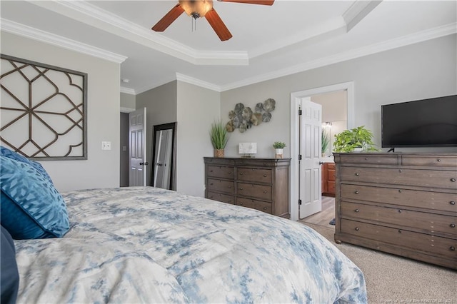 bedroom with crown molding, a ceiling fan, a raised ceiling, and light carpet