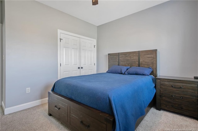 bedroom with baseboards, light colored carpet, ceiling fan, and a closet