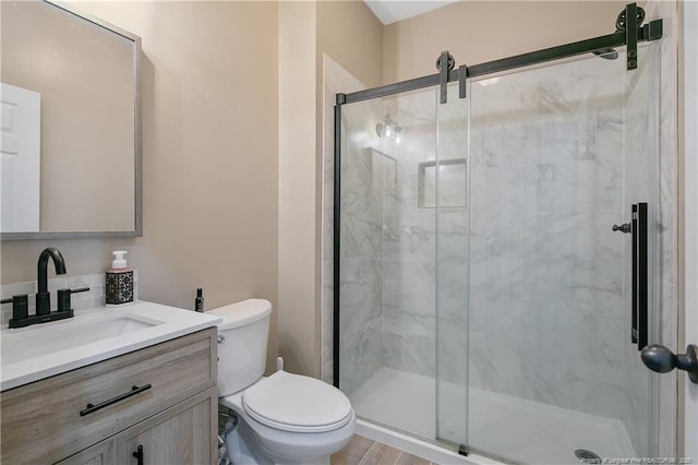 bathroom featuring vanity, a marble finish shower, and toilet