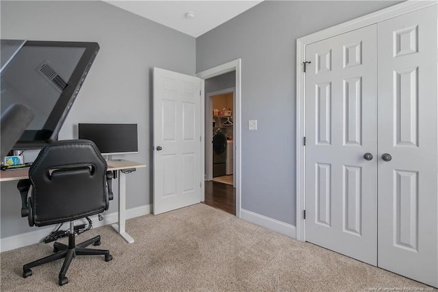 carpeted home office featuring baseboards, visible vents, and washer / dryer