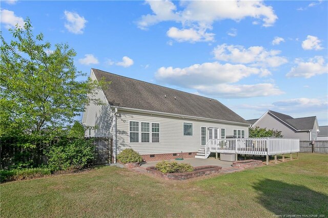 back of house featuring fence, a deck, crawl space, a lawn, and a patio