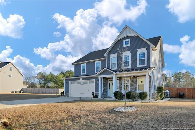 traditional-style home with a porch, driveway, a garage, fence, and stone siding