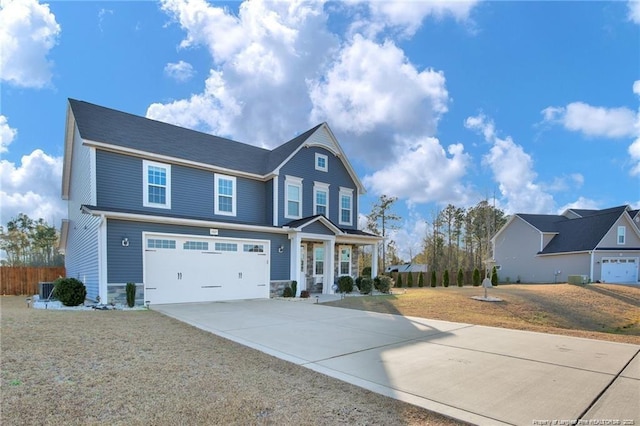 craftsman-style house with driveway, fence, a front lawn, an attached garage, and stone siding