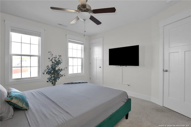 carpeted bedroom with a ceiling fan, baseboards, and visible vents
