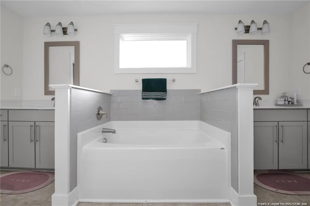 bathroom with a sink, a bath, and two vanities