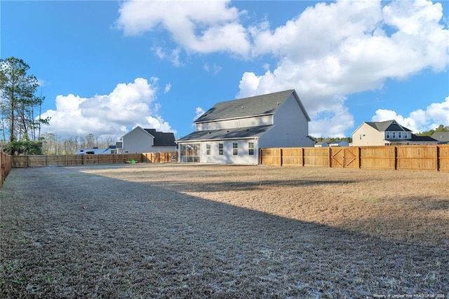 rear view of house with a fenced backyard