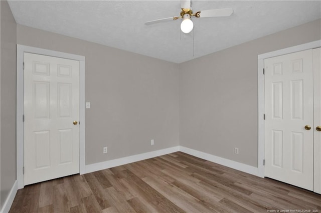empty room featuring baseboards, ceiling fan, and wood finished floors