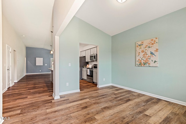 unfurnished living room with baseboards, high vaulted ceiling, ceiling fan, and wood finished floors