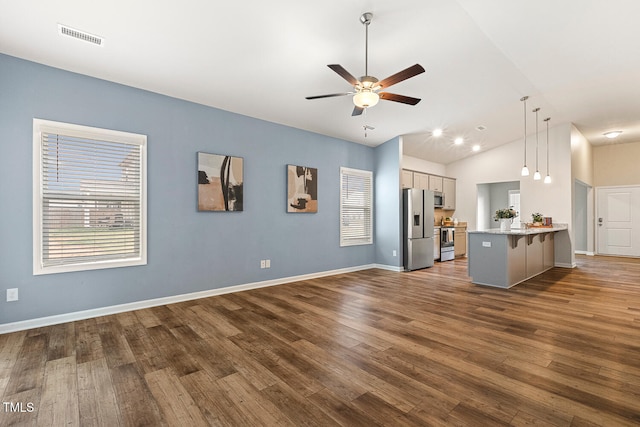 unfurnished living room featuring lofted ceiling, baseboards, dark wood finished floors, visible vents, and ceiling fan