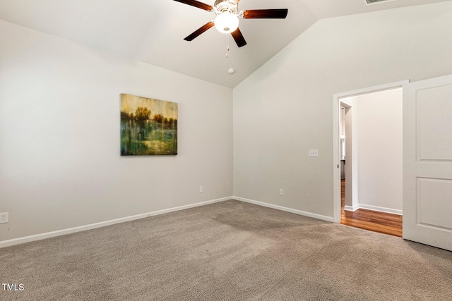 carpeted spare room with a ceiling fan, baseboards, and high vaulted ceiling