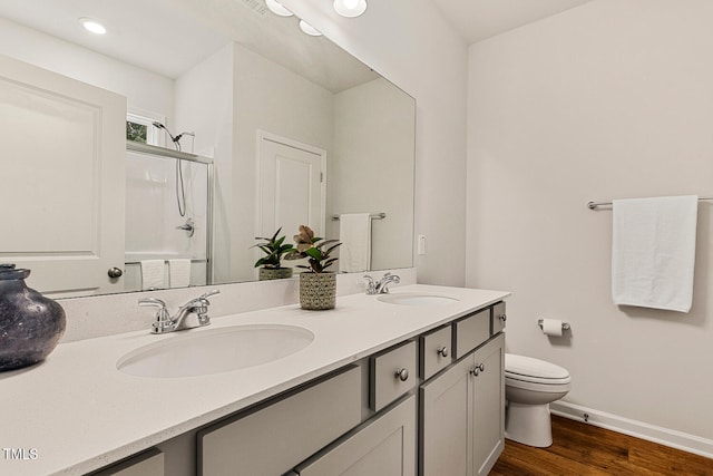 full bathroom with wood finished floors, baseboards, a shower stall, and a sink