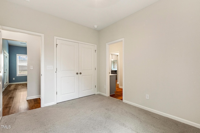unfurnished bedroom with baseboards, a closet, and carpet floors