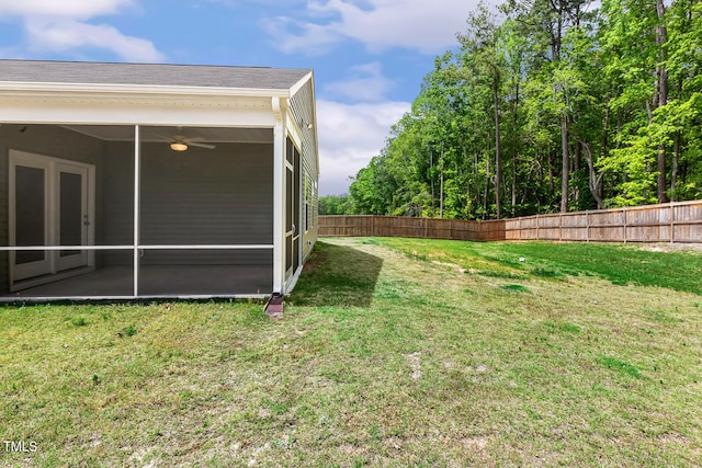 view of yard featuring a sunroom, fence, and a ceiling fan