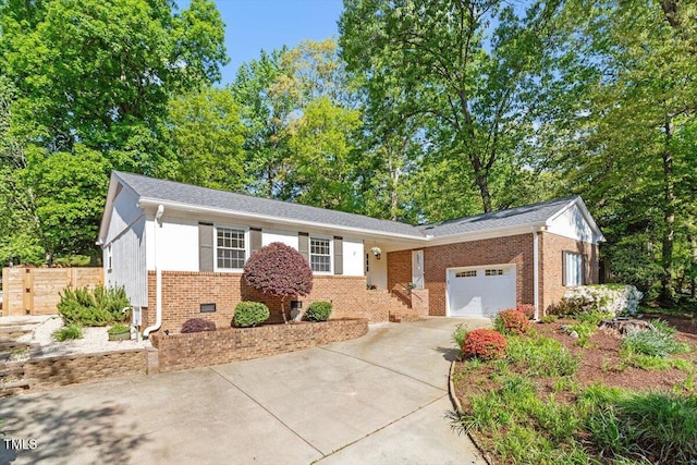 single story home with a garage, concrete driveway, and brick siding