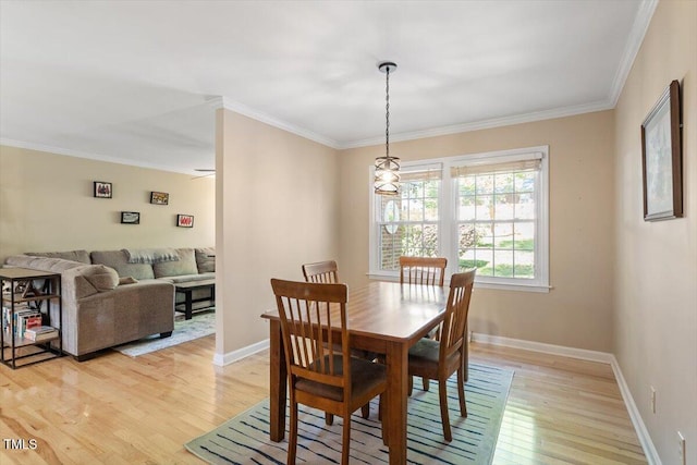 dining area with crown molding, light wood-style flooring, and baseboards