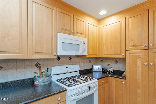 kitchen featuring white appliances, light brown cabinetry, dark countertops, and decorative backsplash