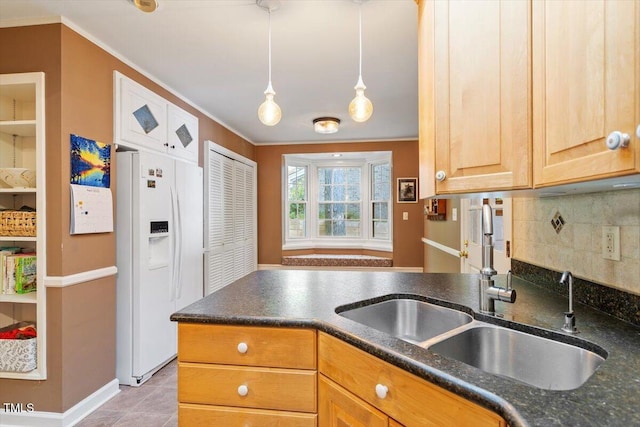 kitchen featuring crown molding, decorative backsplash, white refrigerator with ice dispenser, a sink, and light tile patterned floors