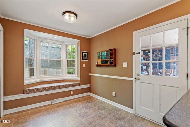 doorway to outside featuring baseboards, ornamental molding, and visible vents