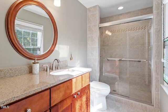 bathroom with a shower stall, vanity, tile patterned floors, toilet, and recessed lighting