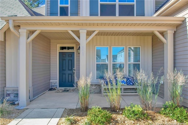 308 Wishaw Ct, Hope Mills, NC 28348 - view of exterior entry featuring board and batten siding, covered porch, and stone siding