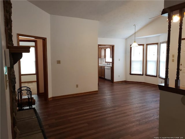 unfurnished living room featuring baseboards, vaulted ceiling, and dark wood-type flooring