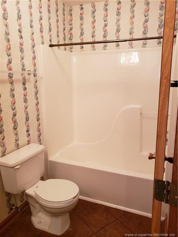 full bath featuring toilet, tile patterned floors, and shower / tub combination