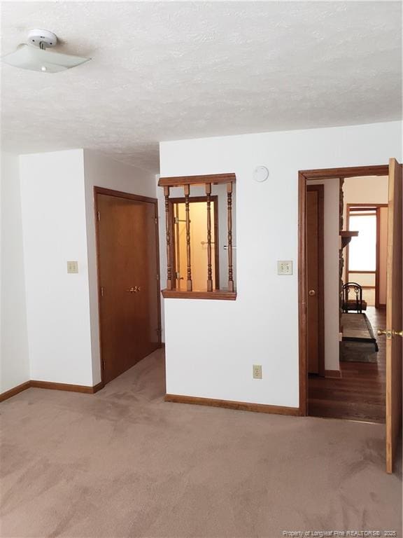 spare room featuring carpet floors and baseboards