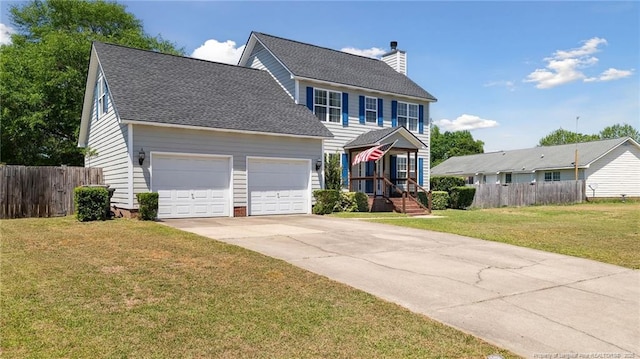 colonial inspired home featuring fence, an attached garage, a front yard, a chimney, and driveway