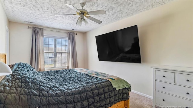carpeted bedroom featuring visible vents, a ceiling fan, a textured ceiling, and baseboards