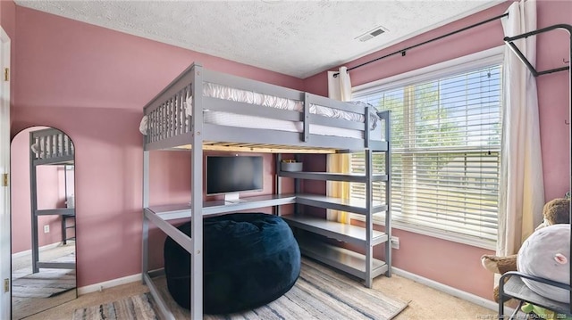 bedroom featuring baseboards, a textured ceiling, carpet, and visible vents
