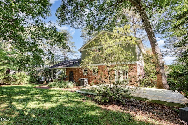 1324 Swallow Dr, Raleigh, NC 27606 - back of house with a wooden deck, brick siding, and a yard