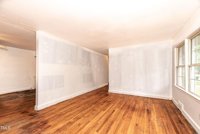 spare room with hardwood / wood-style flooring and baseboards