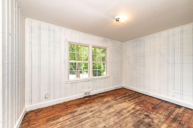 unfurnished room with wood-type flooring and baseboards