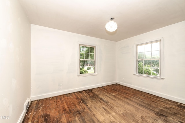 unfurnished room with wood-type flooring, plenty of natural light, and baseboards