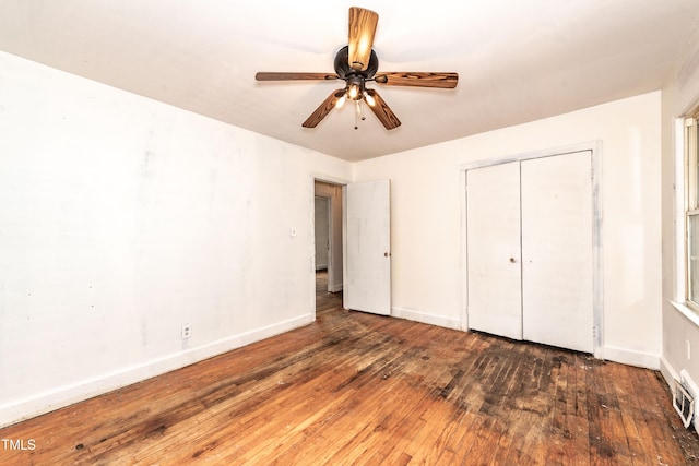 unfurnished bedroom featuring wood-type flooring, baseboards, a closet, and ceiling fan