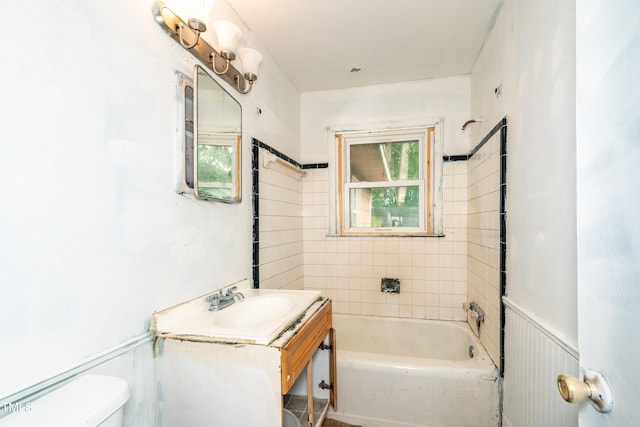 full bathroom with toilet, a tub, vanity, a wainscoted wall, and a shower